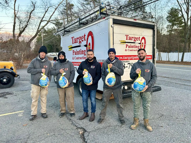 Five Target Painting painters in front of a company truck, each holding a turkey to give away