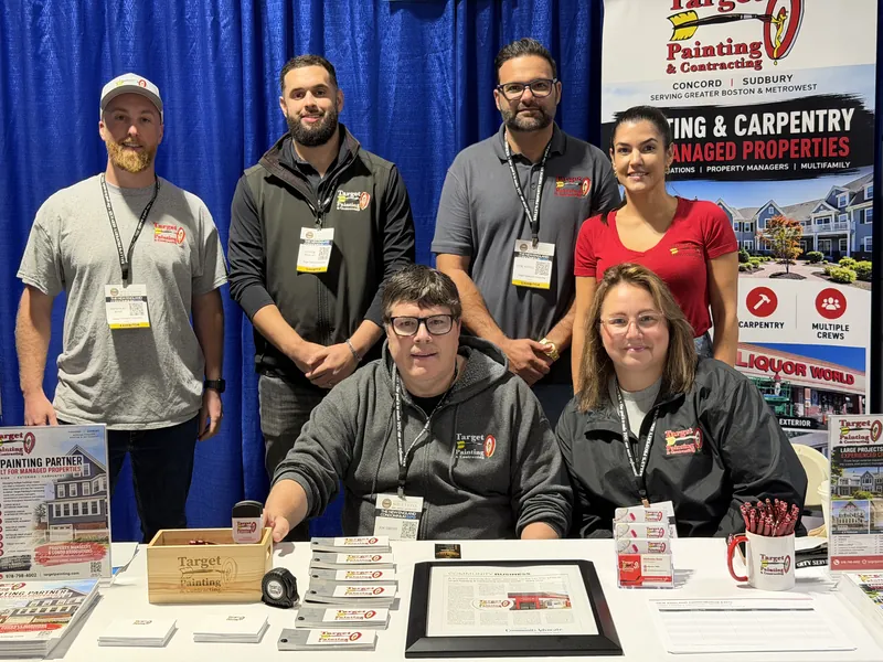 Six members of the Target Painting team smiling together at their trade show booth
